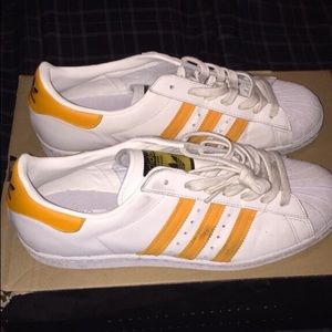 white adidas with orange stripes